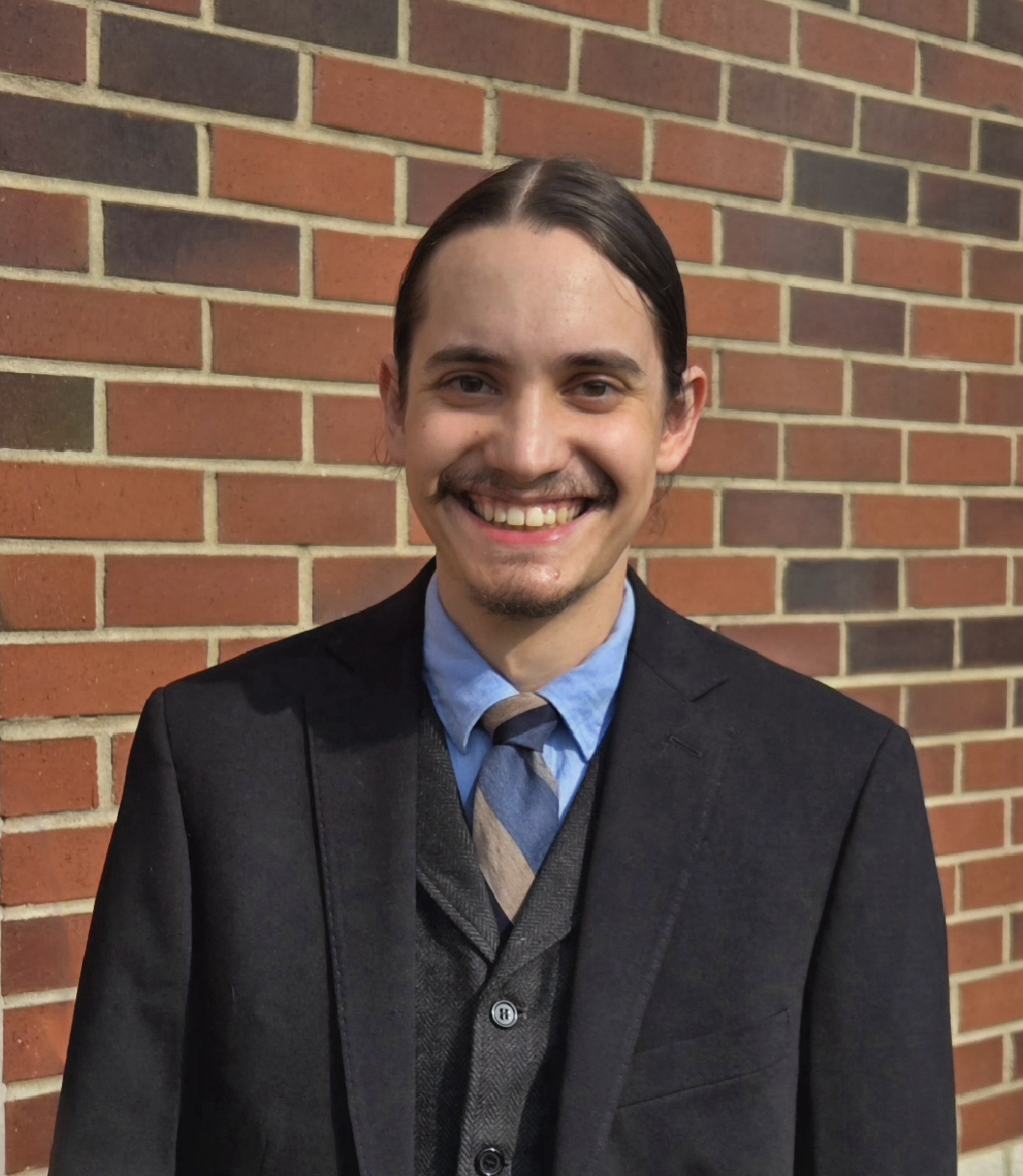 Brendan Amin stranding outside in front of a brick wall